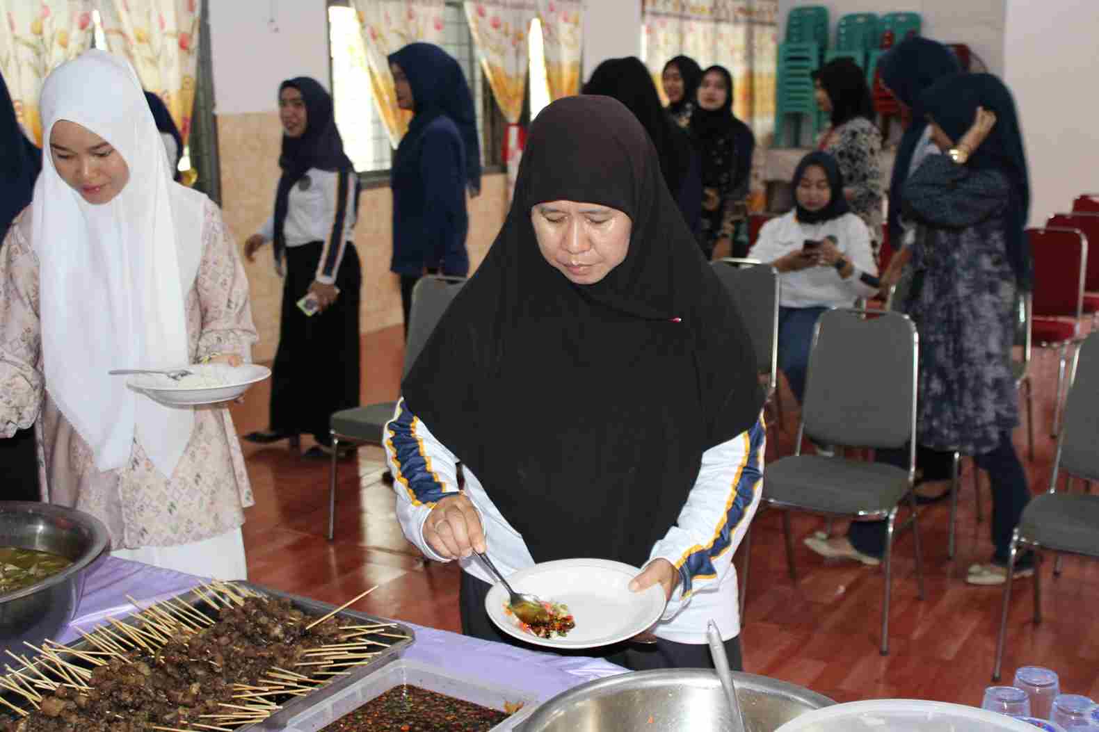 Kepala Lapas Perempuan Kelas IIA Bandar Lampung, Amiek Diyah Ambarwati, tengah mengambil sajian makan bersama dengan para pegawai.